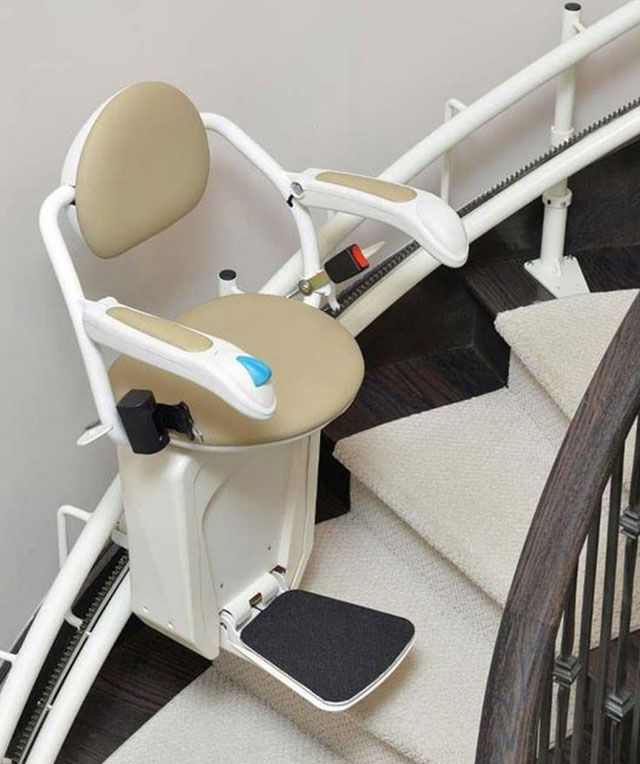 A Curved Stair Lift with A Beige Seat — Master Lifts Cairns in Cairns, QLD