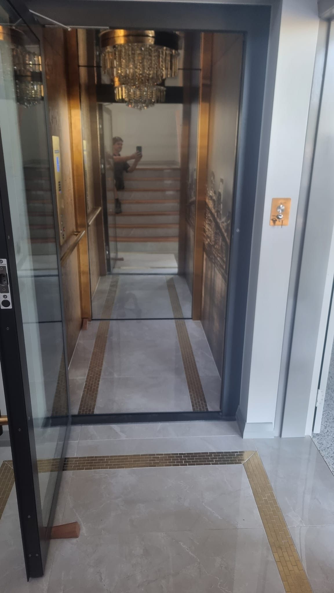 A Glass Elevator with Stairs Leading up To It in A Hallway — Master Lifts Cairns in Cassowary Coast, QLD