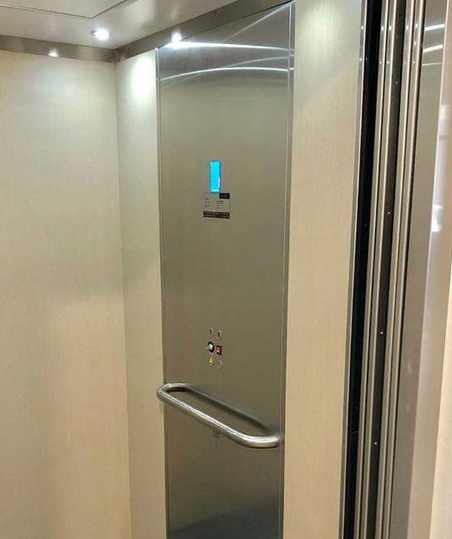 A Stainless Steel Door in An Elevator with A Handle — Master Lifts Cairns in Cairns, QLD