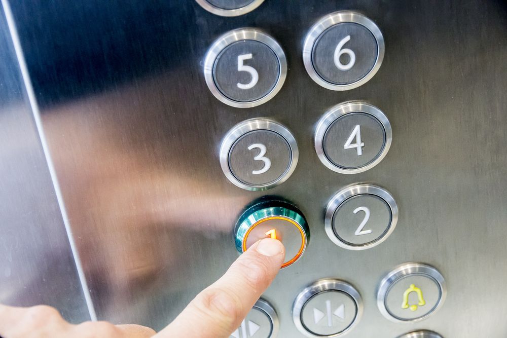 A Person Is Pressing a Button in An Elevator — Master Lifts Cairns in Cairns, QLD