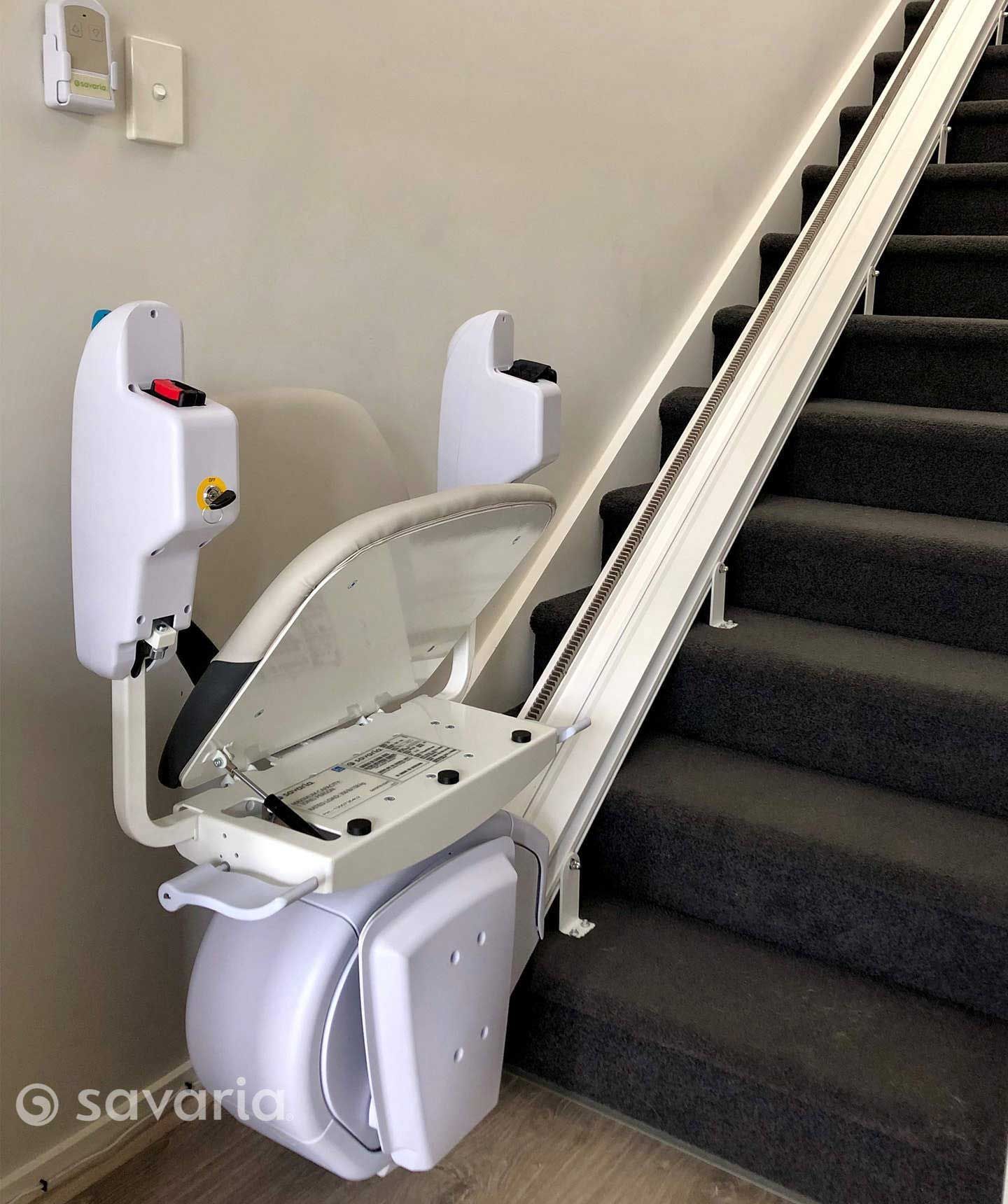 A White Stair Lift Is Sitting on A Set of Stairs — Master Lifts Cairns in Cairns, QLD