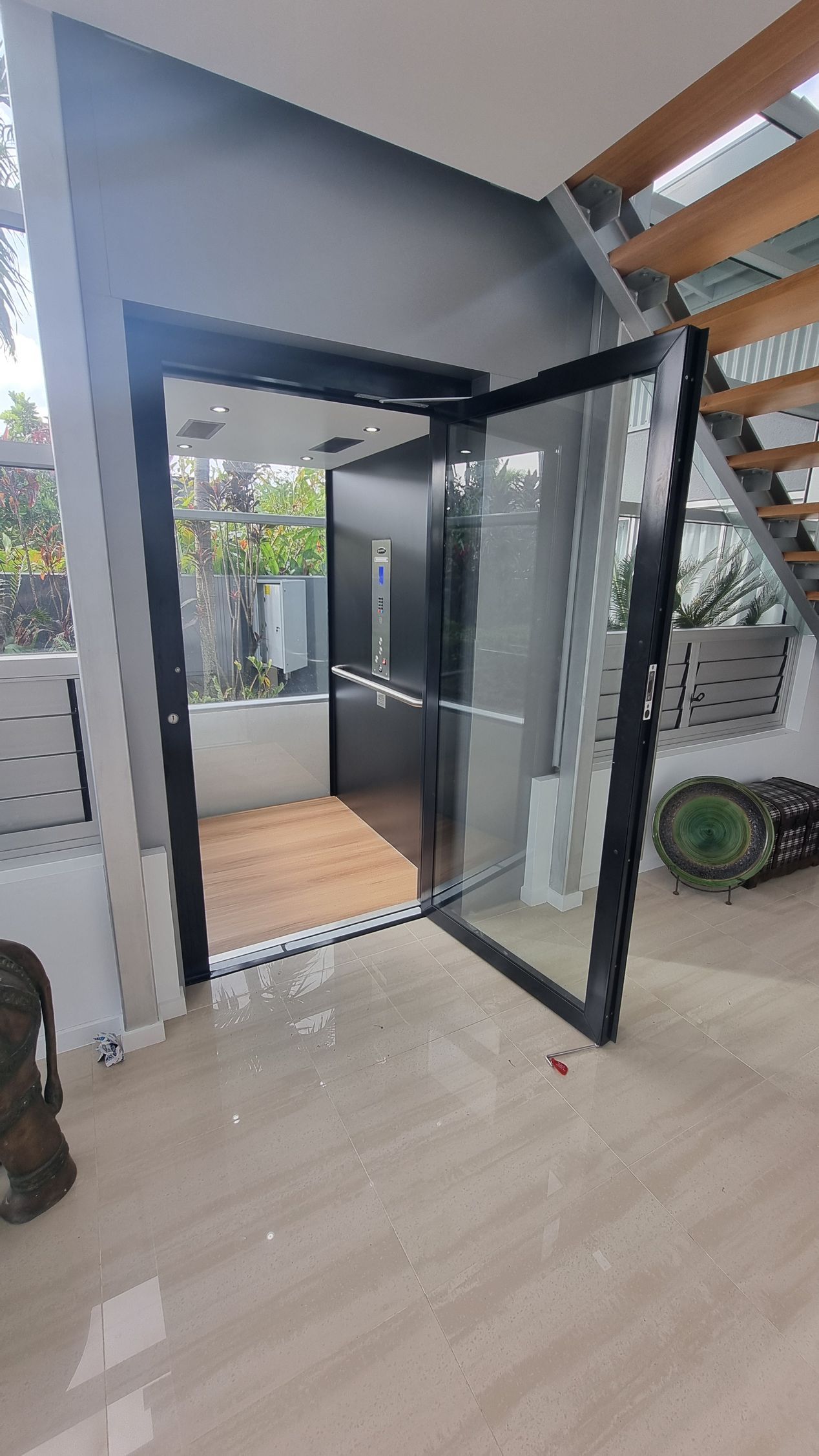 A Large Glass Door Is Open in A Room with Stairs — Master Lifts Cairns in Cairns, QLD