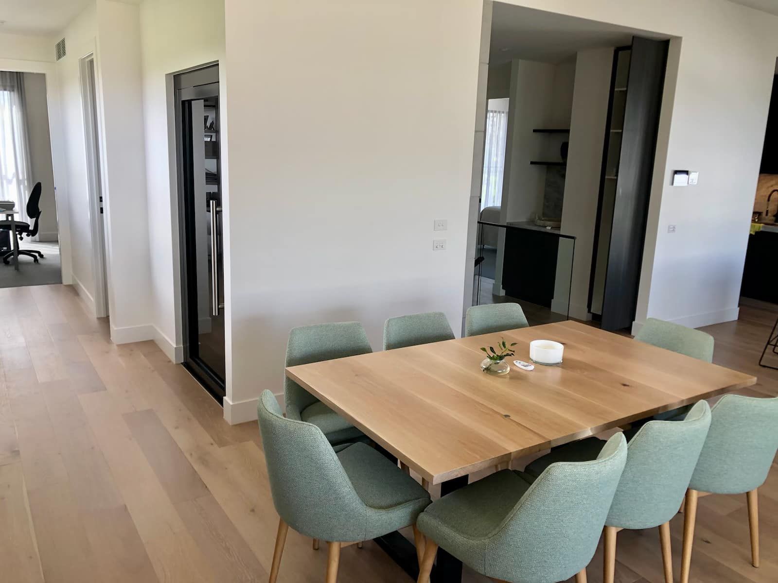 A Dining Room with A Wooden Table and Green Chairs — Master Lifts Cairns in Cairns, QLD
