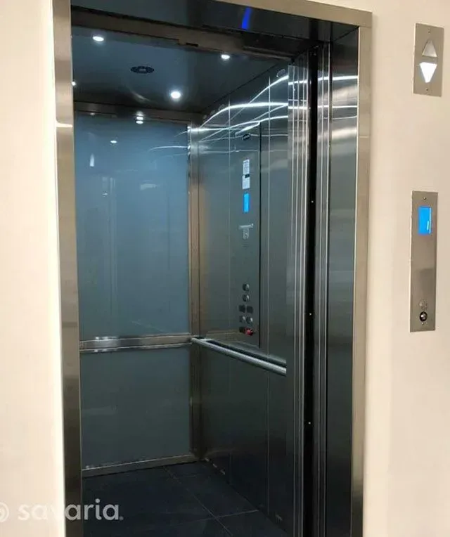 A stainless steel elevator with a glass door