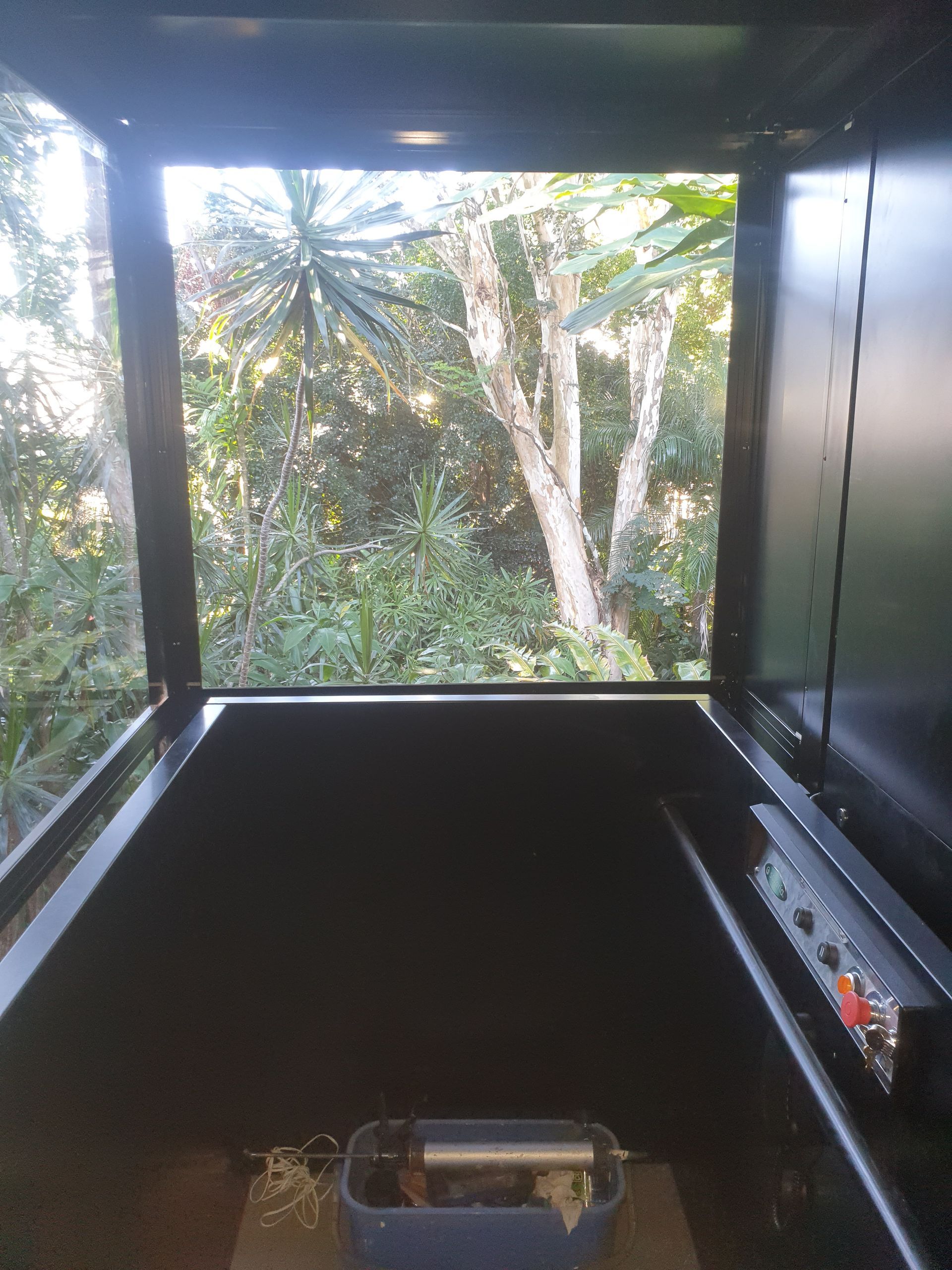 The Inside of An Elevator with A Window Looking out To a Forest — Master Lifts Cairns in Cairns, QLD