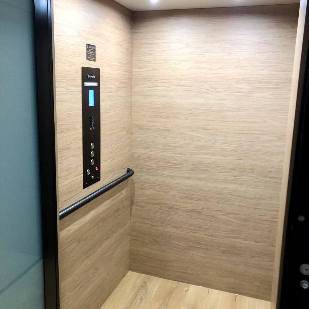 A Wooden Elevator with A Black Handle and Buttons on The Wall — Master Lifts Cairns in Cairns, QLD