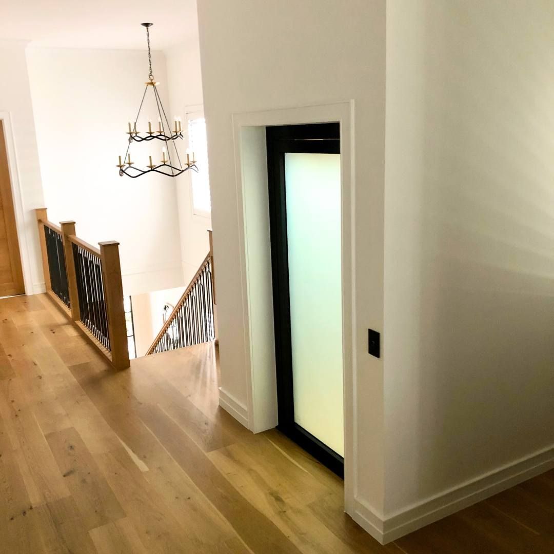 A Hallway with Hardwood Floors and A Staircase in The Background — Master Lifts Cairns in Cairns, QLD