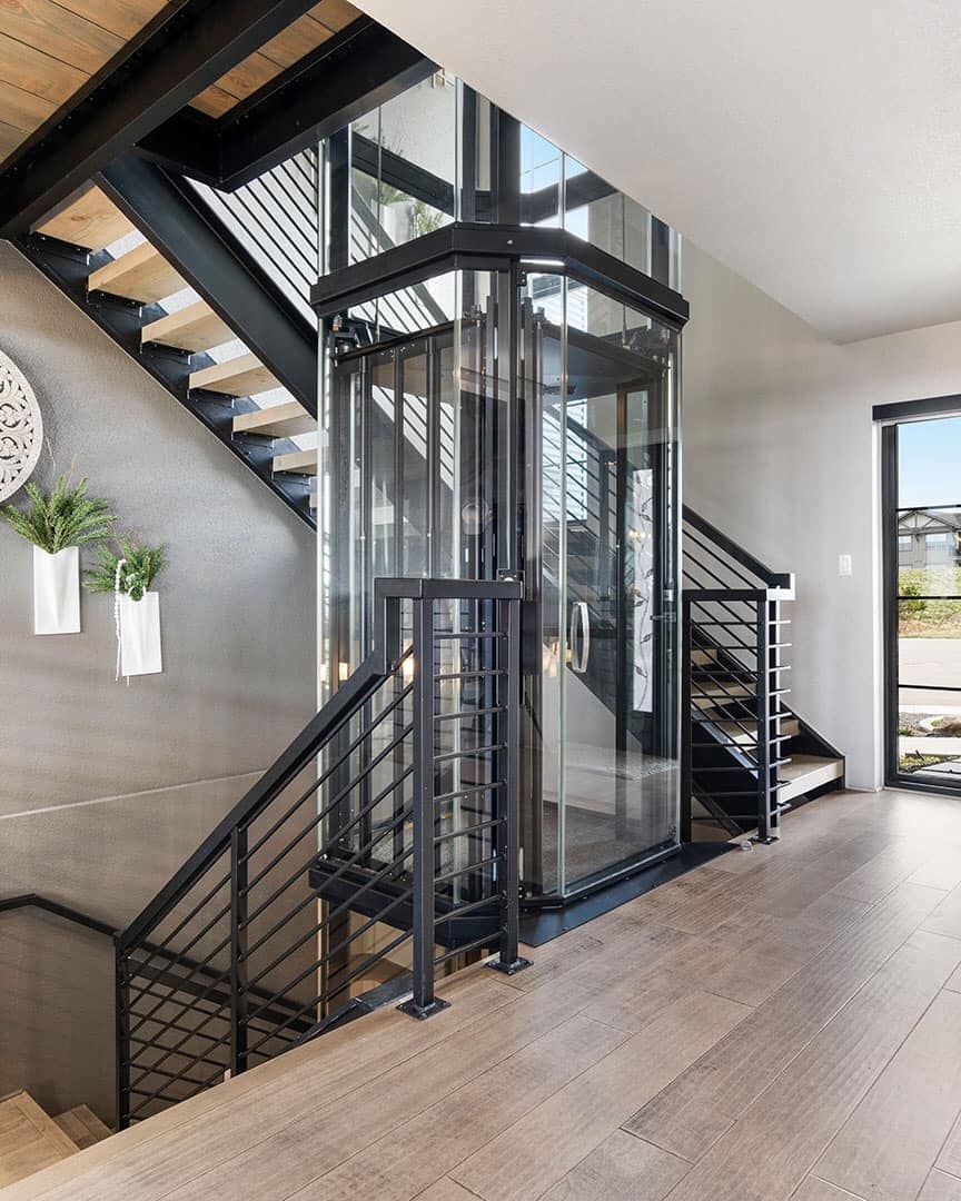 A Staircase with A Glass Elevator in The Middle of It — Master Lifts Cairns in Cairns, QLD