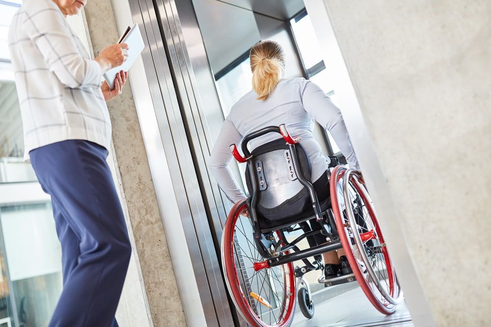 Woman In A Wheelchair Traveling With The Elevator In The Business Company — Master Lifts Cairns in Cairns, QLD