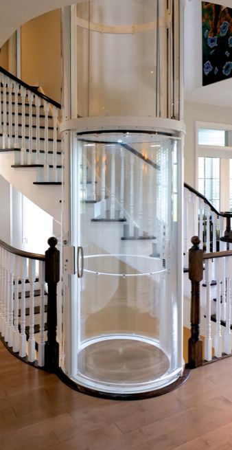 A Glass Elevator Is in The Middle of A Staircase — Master Lifts Cairns in Cairns, QLD