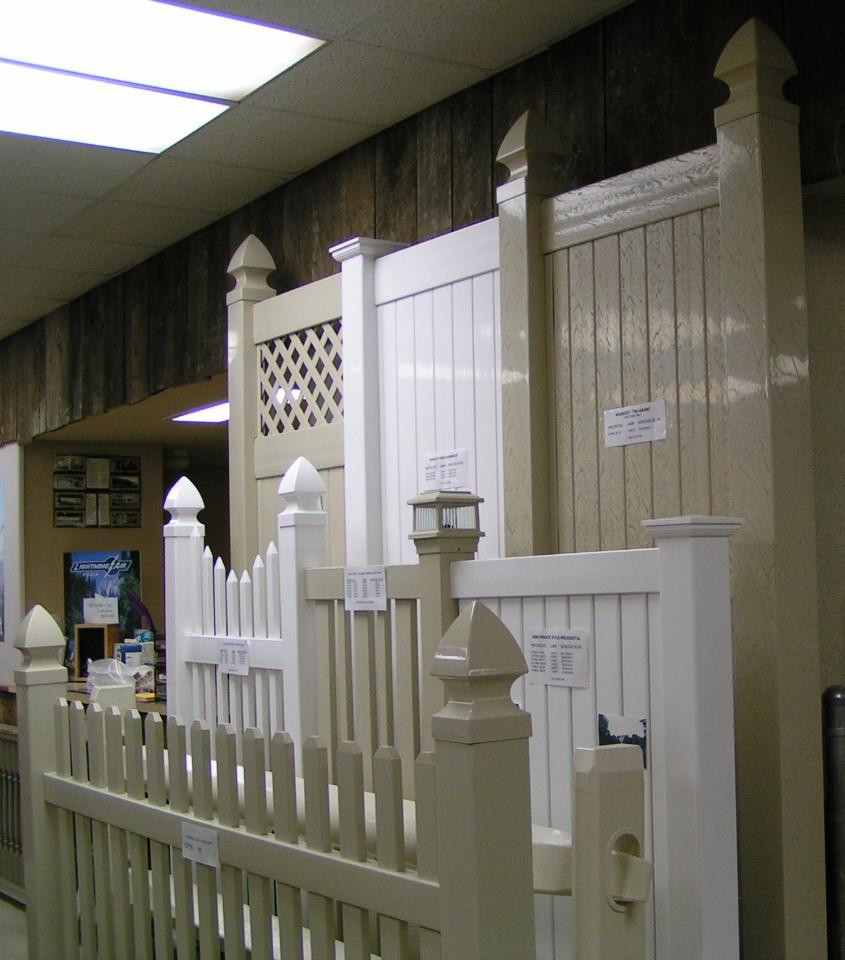 Various white and beige fence styles on display indoors.