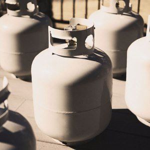 White propane tanks grouped outdoors.
