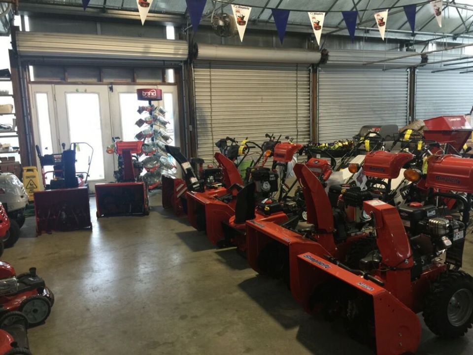 Snow blowers lined up inside a hardware store.