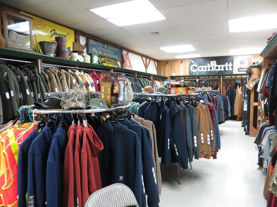 Clothing store interior with racks of Carhartt jackets and apparel.