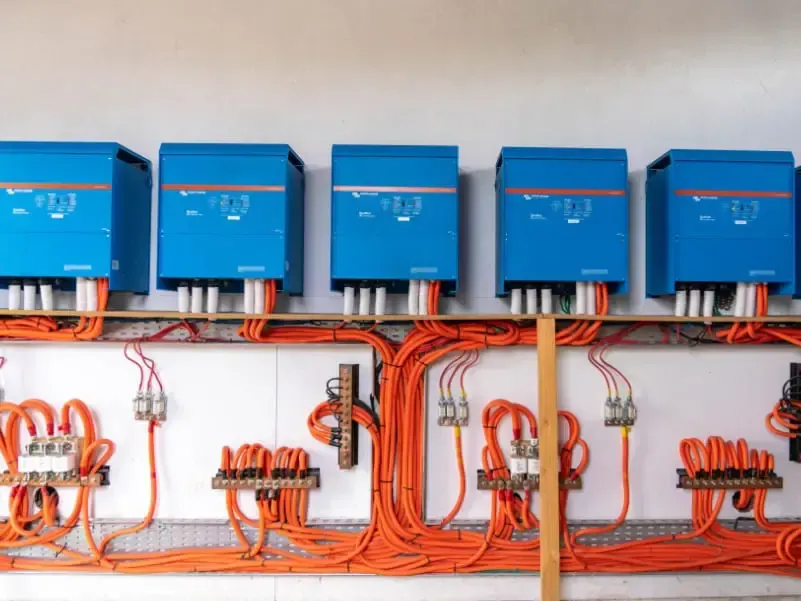 A row of blue boxes with orange wires attached to them.