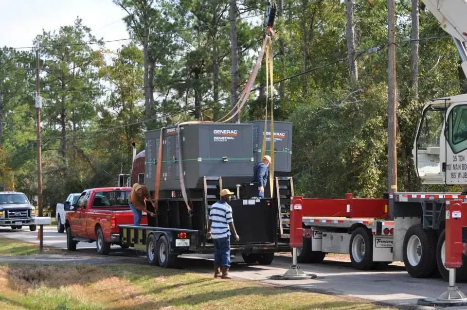A red truck is being towed by a crane
