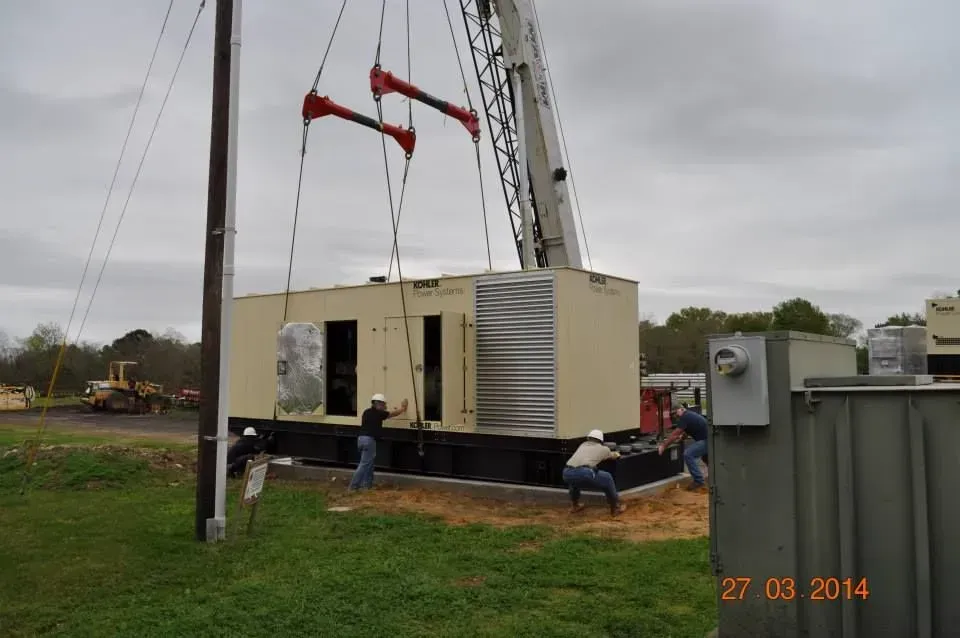 A crane is lifting a large box in a field.