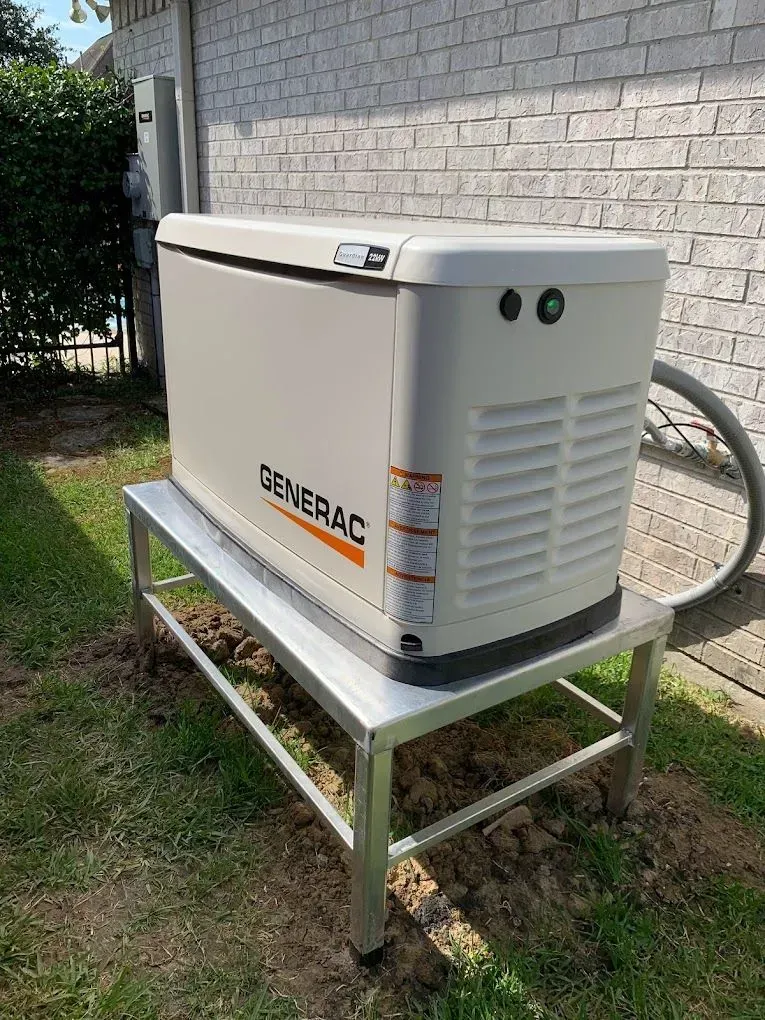 A generator is sitting on top of a metal stand in front of a brick building.
