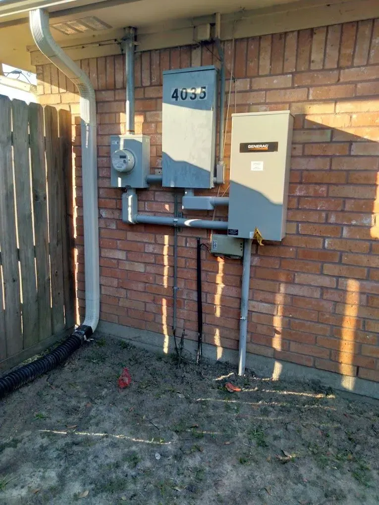 A brick wall with electrical boxes attached to it.