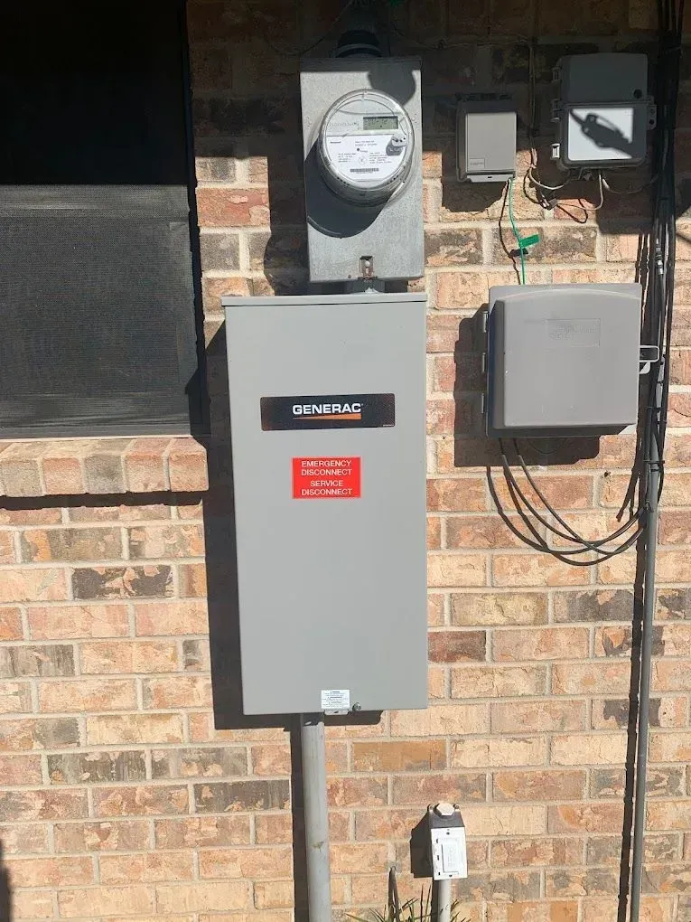 A gray box is sitting on a brick wall next to a meter.