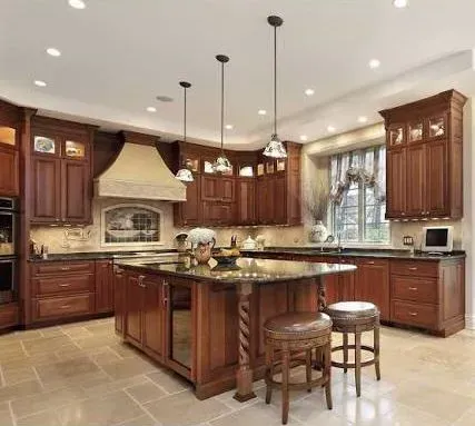 A kitchen with wooden cabinets , granite counter tops , and a large island.