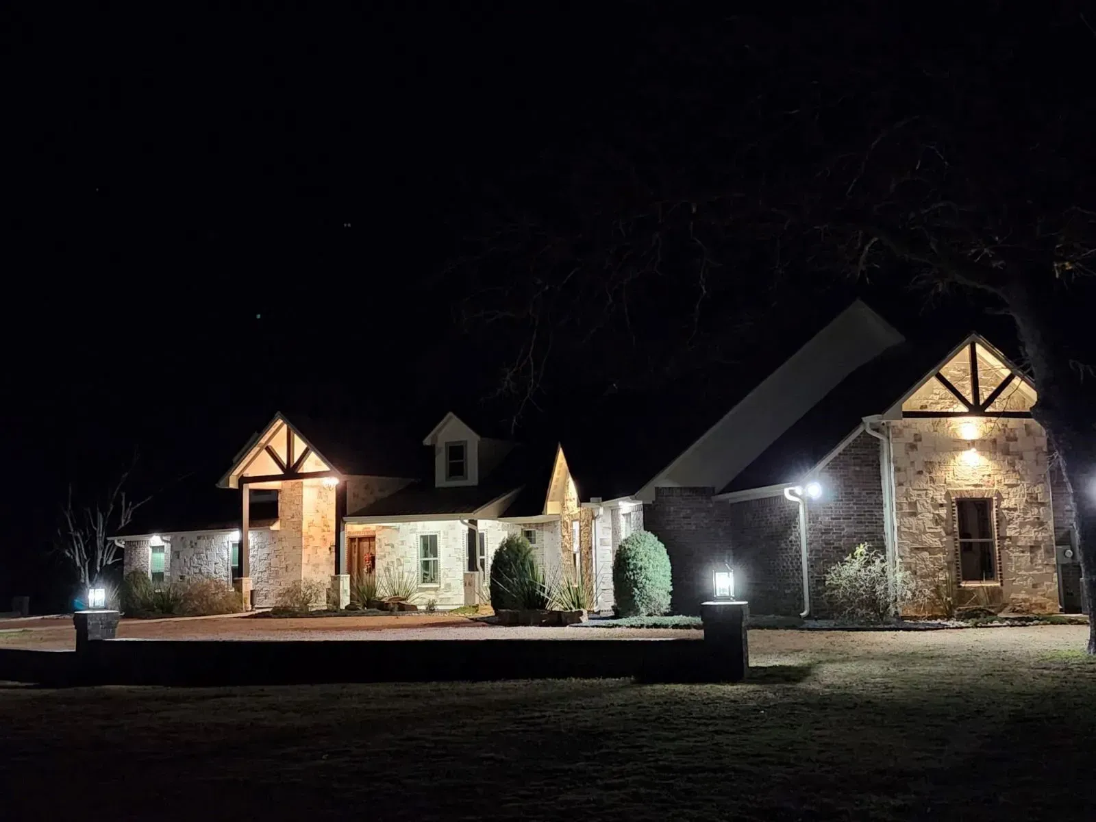 A large stone house is lit up at night.