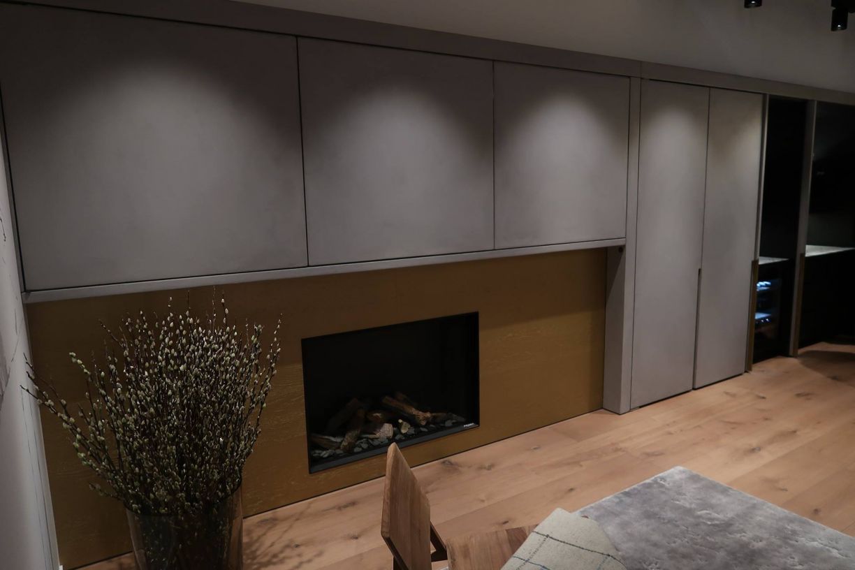 een woonkamer met open haard en een vaas met bloemen