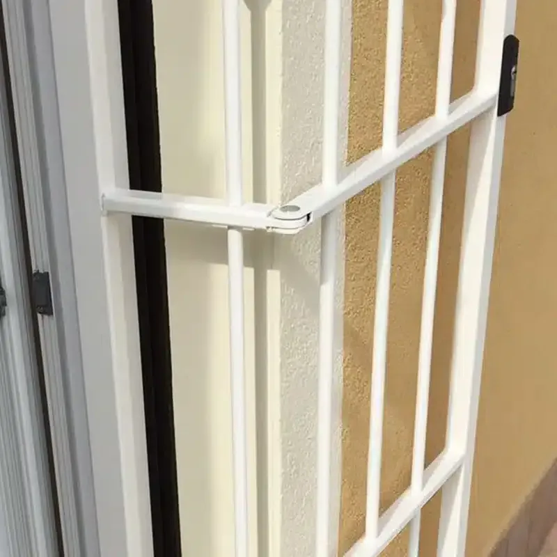 Cancello di sicurezza bianco fissato a un edificio; sono visibili i colori chiari e scuri delle pareti.
