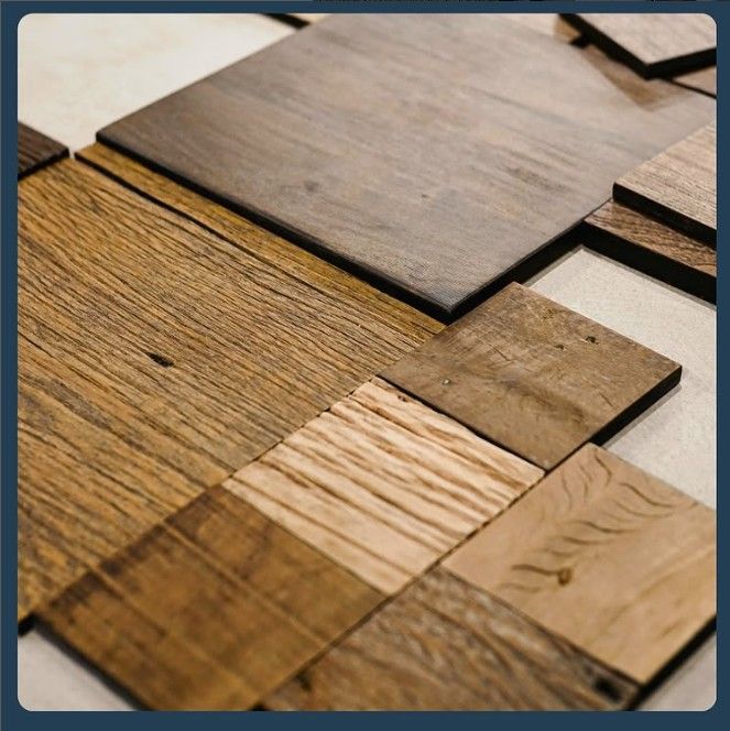 Primo piano di varie piastrelle quadrate in legno con venature e colori diversi, disposte secondo uno schema.
