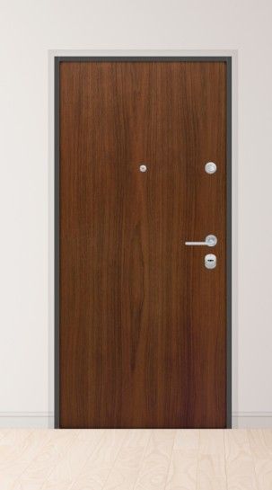 Porta in legno marrone con ferramenta in metallo in una stanza bianca.