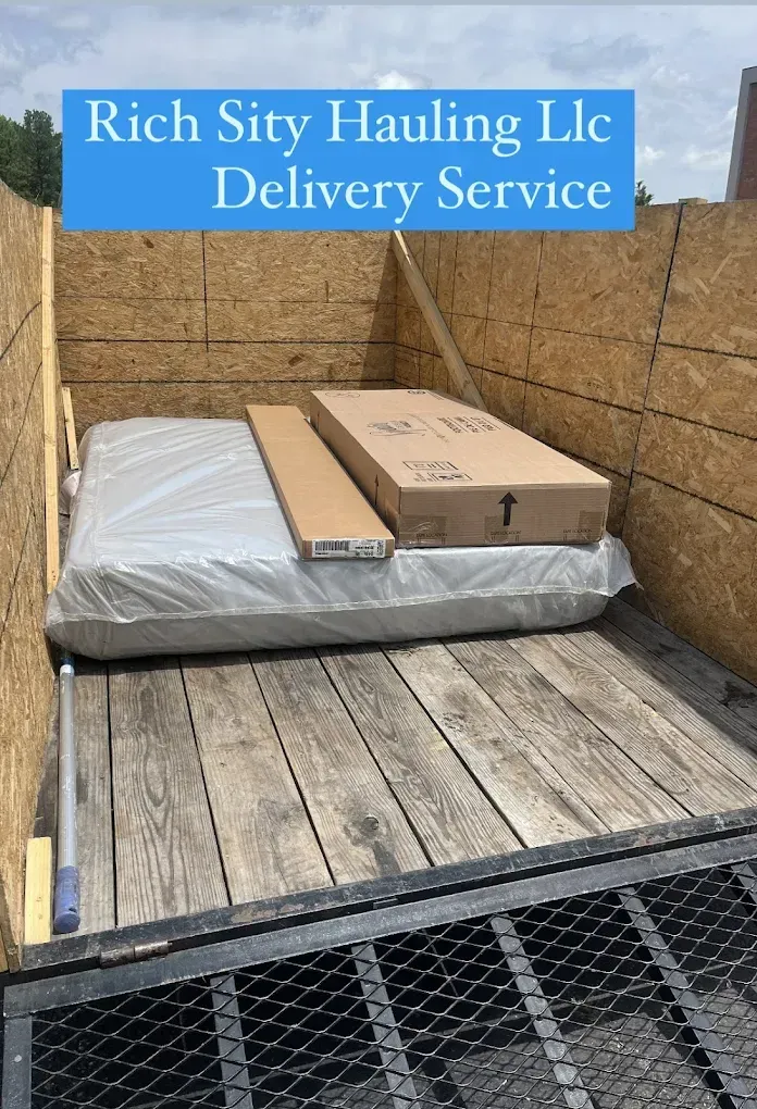 Pickup truck bed with packages under a Rich Sity Hauling LLC Delivery Service sign