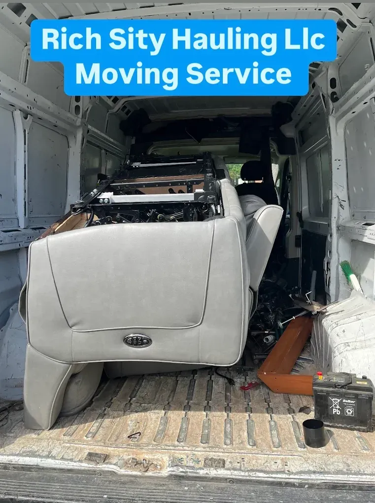 Moving truck loaded with a white sofa and furniture, labeled “Rich City Hauling LLC Moving Service”