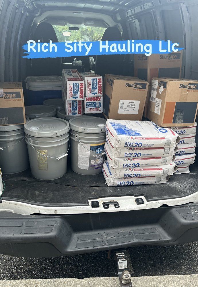 Pickup truck bed loaded with buckets, boxes, and cement bags for Rich Sify Hauling LLC