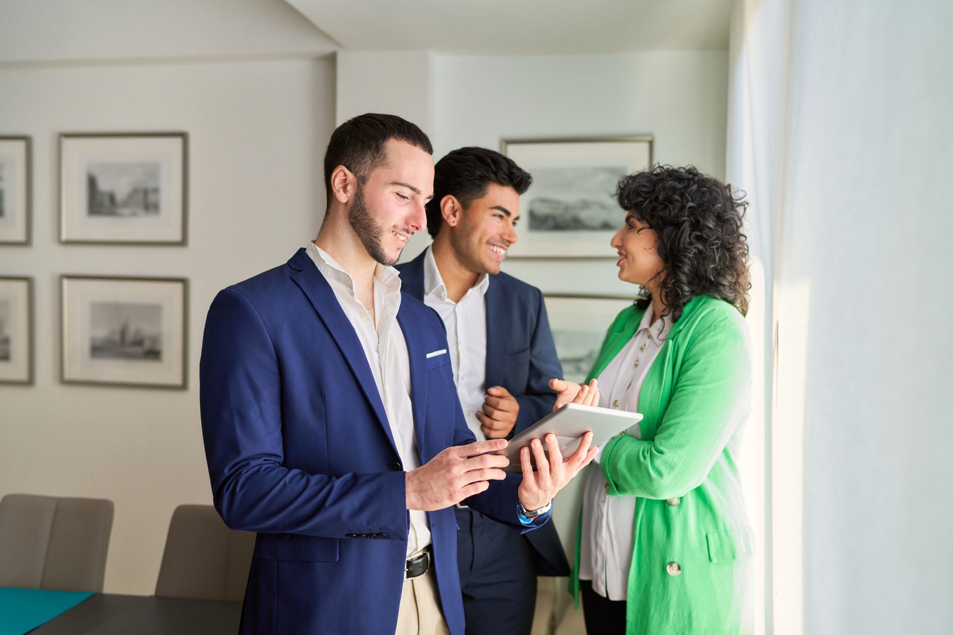 Real estate agent handing keys to a smiling couple after signing a contract.