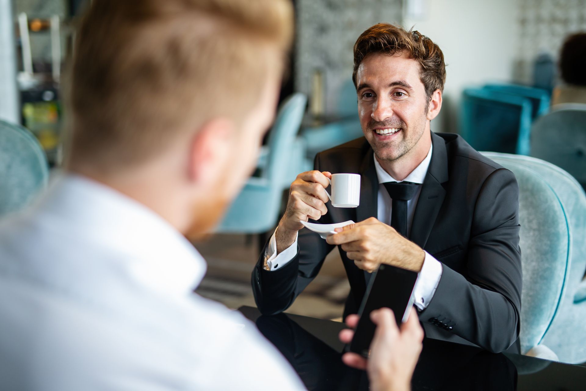 Real estate agent handing keys to a smiling couple after signing a contract.