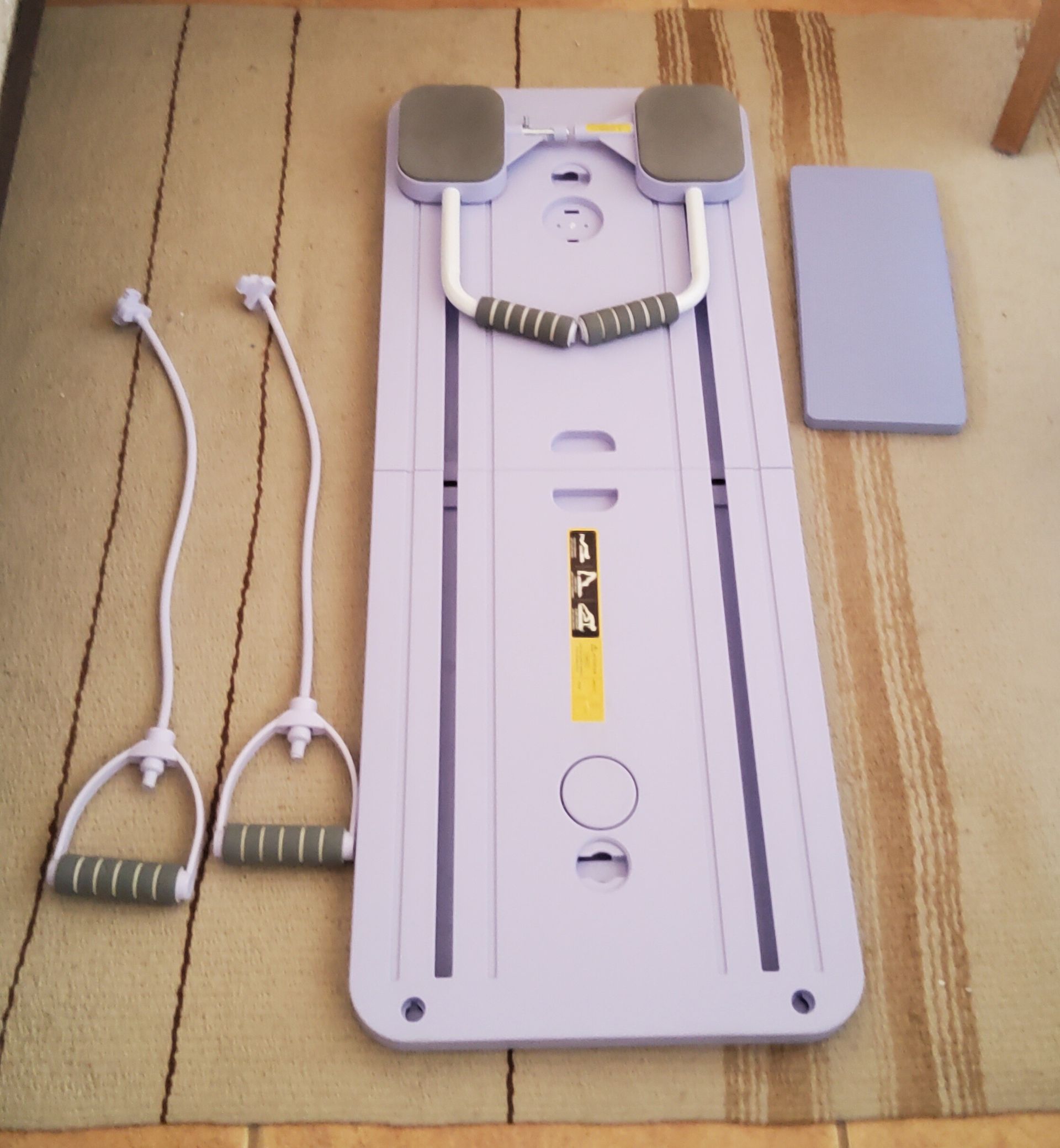 A purple board with a yellow sticker that says ' pilates ' on it