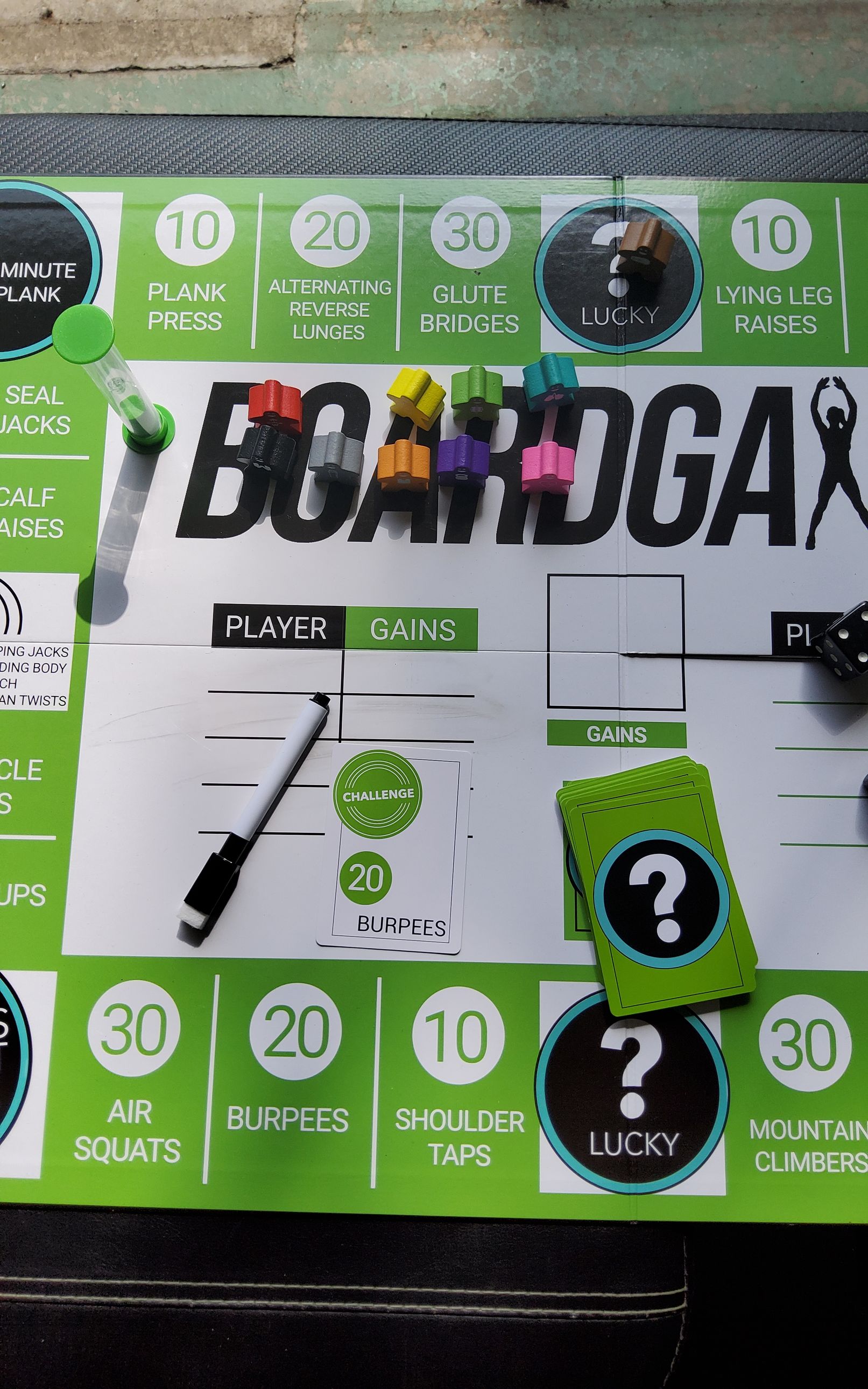 Board game layout with exercise prompts. Green, black, and white design with game pieces and cards.