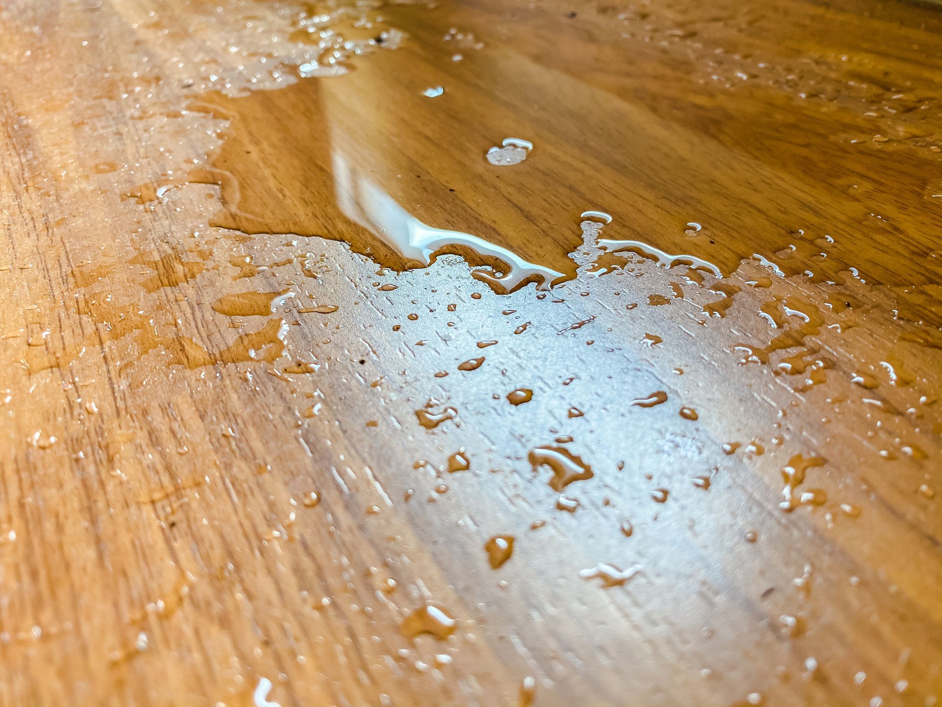 Water spill on wood floor, which is leaking from the air conditioner in the house.