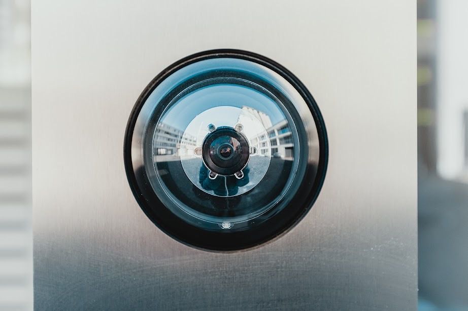 A close up of a security camera on a metal wall.