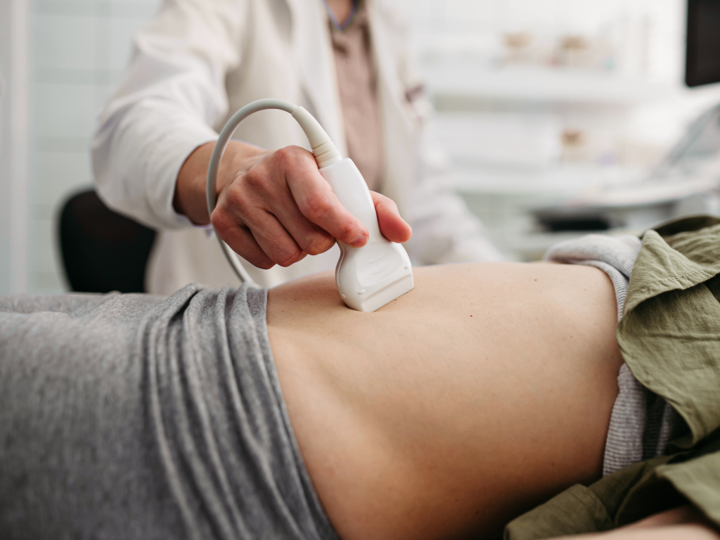 Ultrasound scan on a patient’s abdomen in a clinic setting