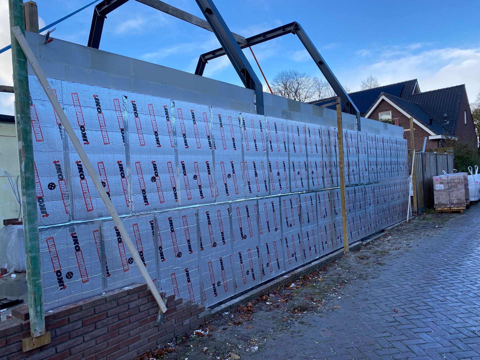 Er wordt een bakstenen muur gebouwd met veel aluminium isolatie