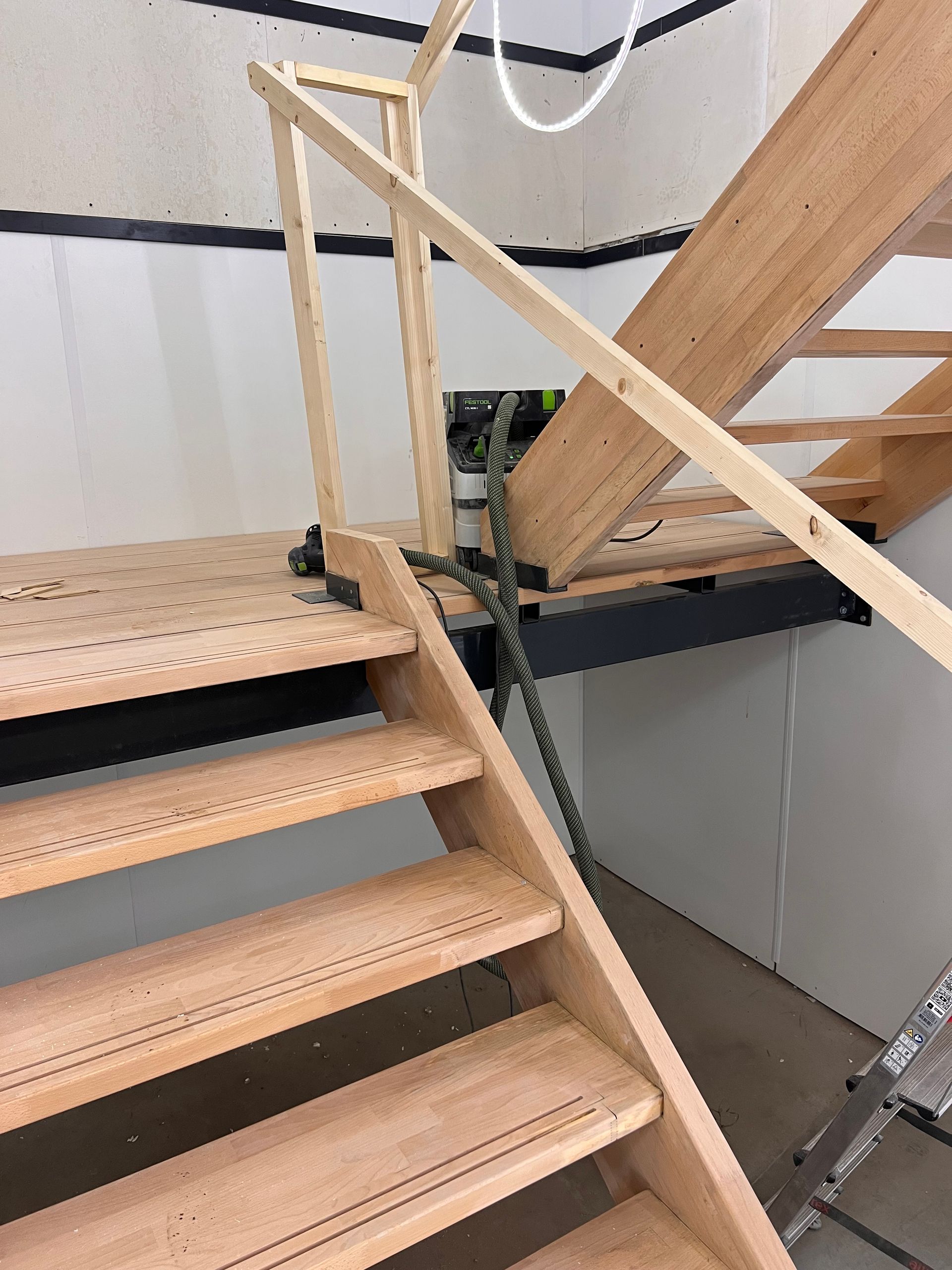 een houten trap met daaraan een stofzuiger