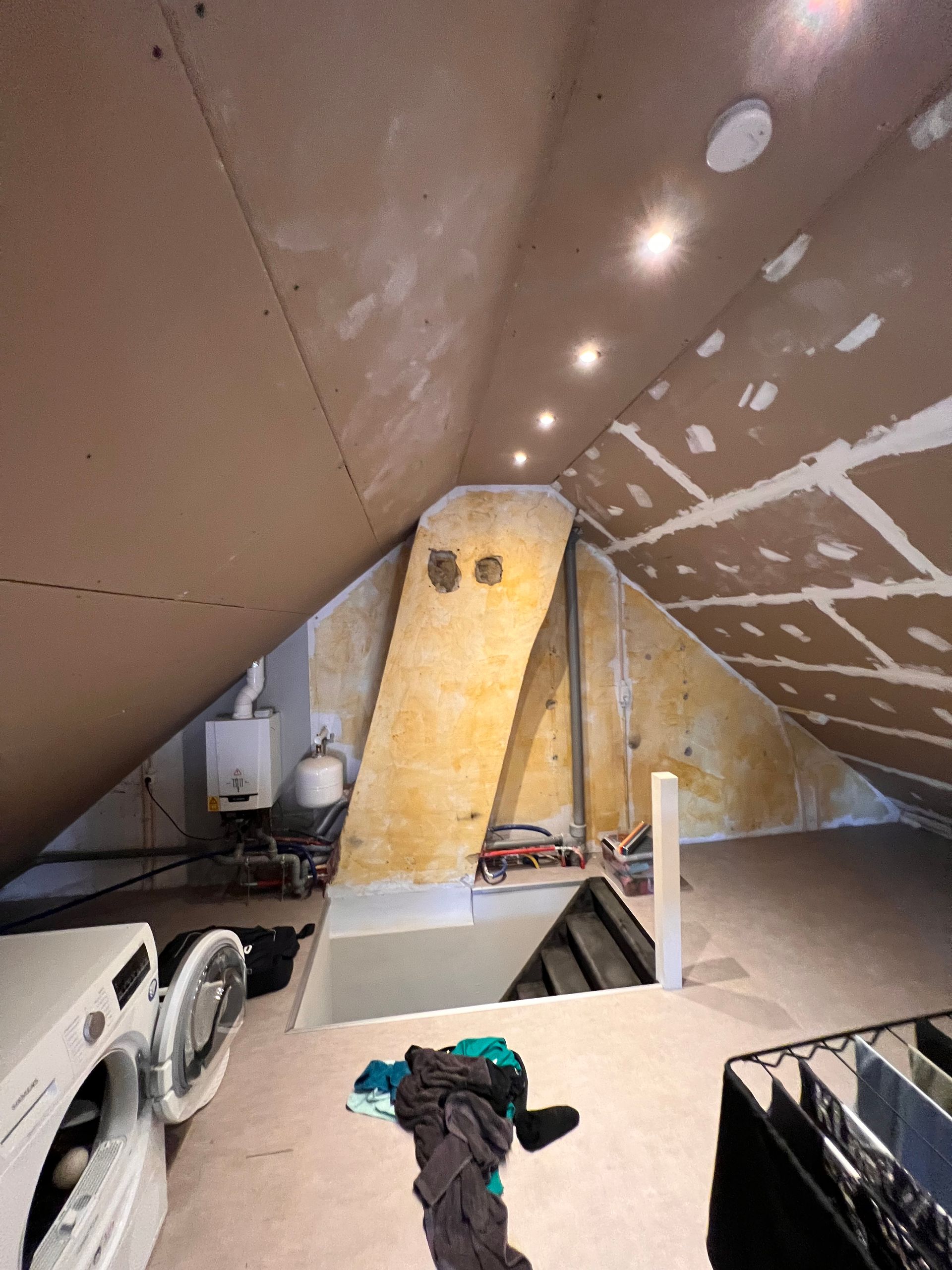 een zolder met daarin een wasmachine en droger