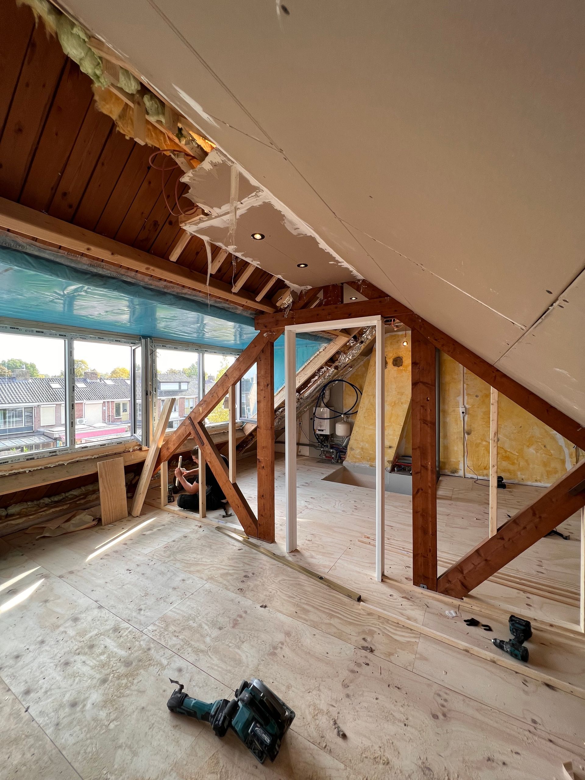 een makita-boormachine staat op een houten vloer op zolder