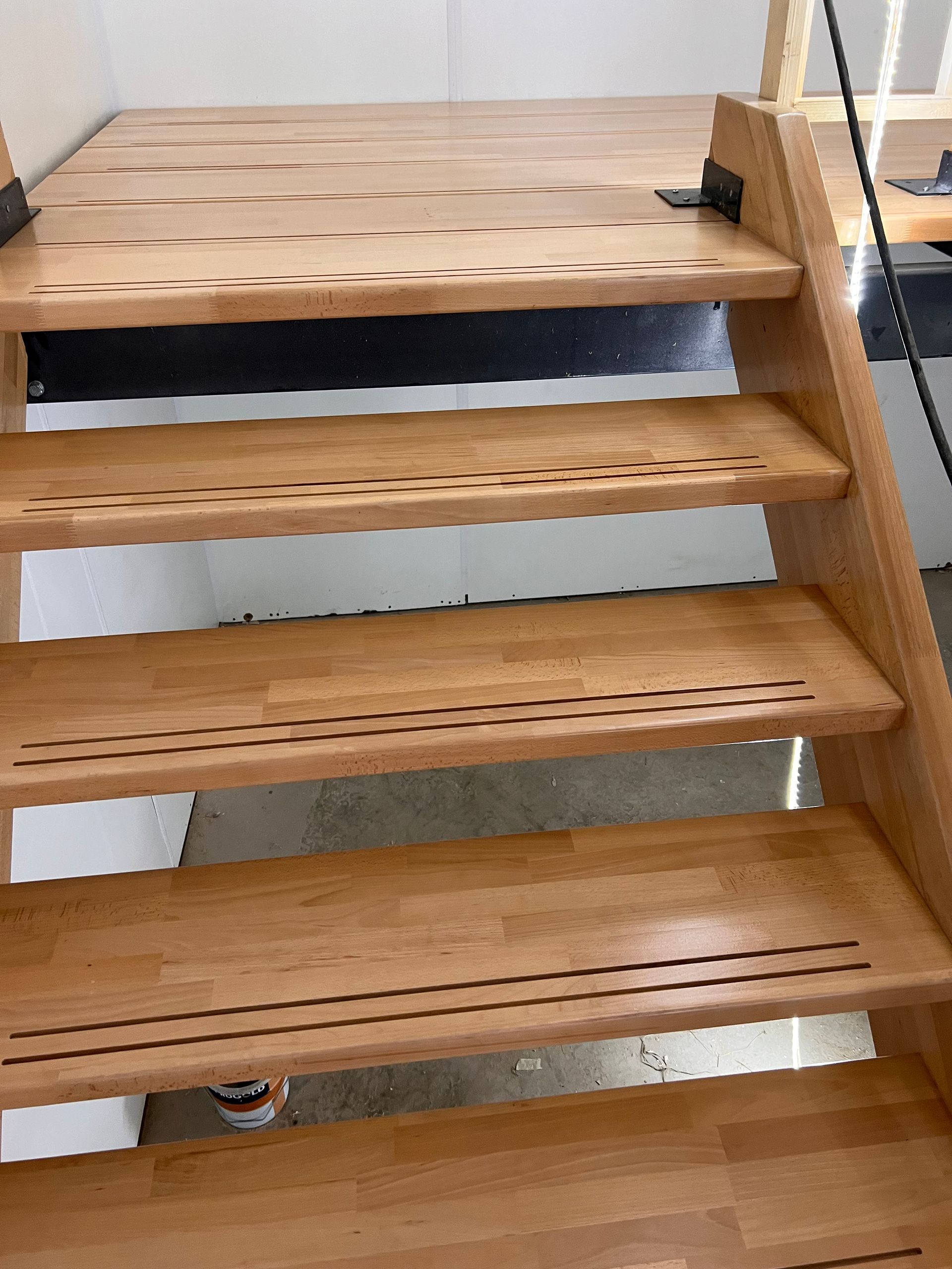 een houten trap met een emmer vlek op de vloer