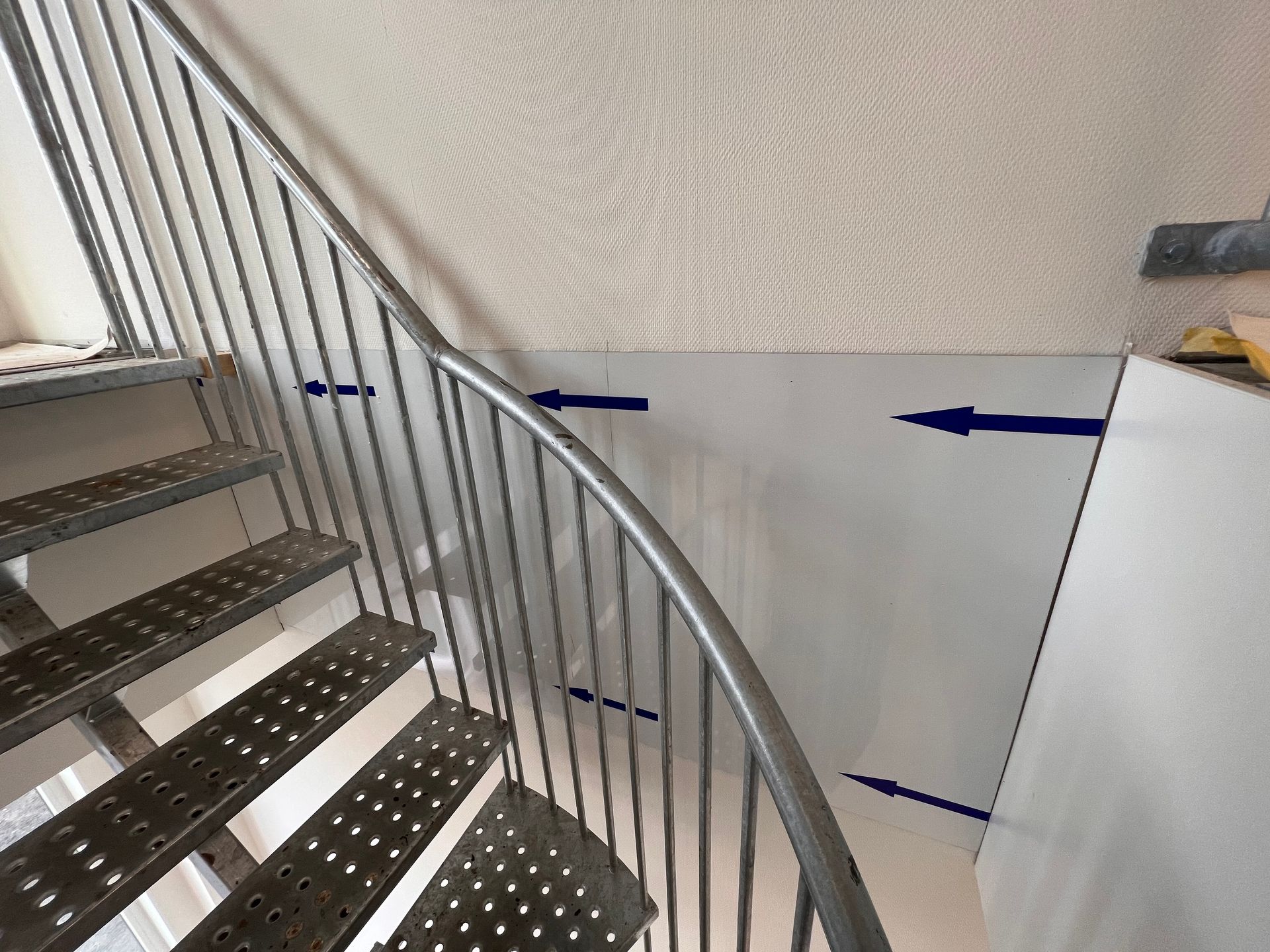 een wenteltrap met blauwe pijlen die naar boven en naar beneden wijzen