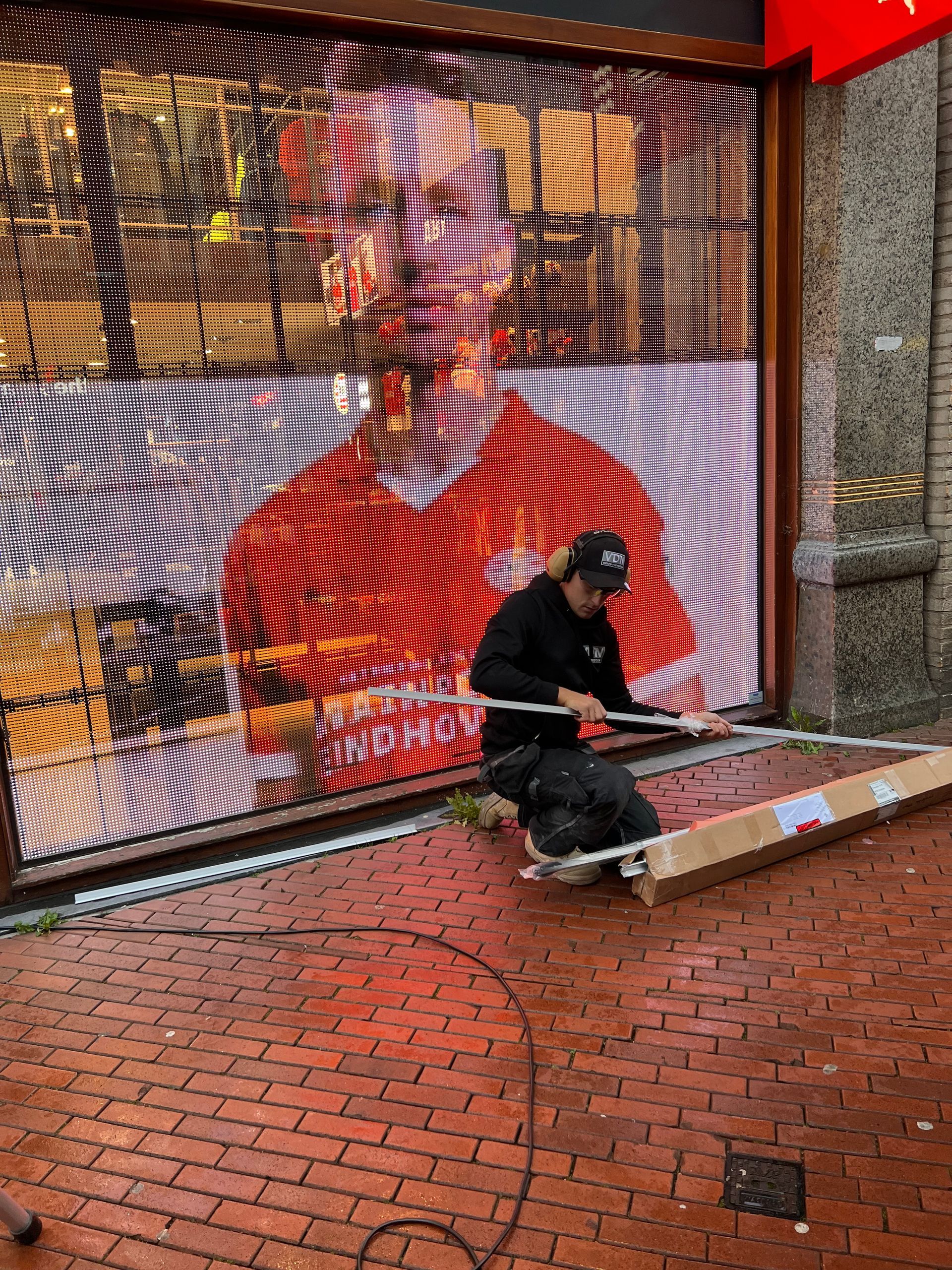 een man werkt aan een groot scherm waar PSV speler Luuk de Jong opstaat