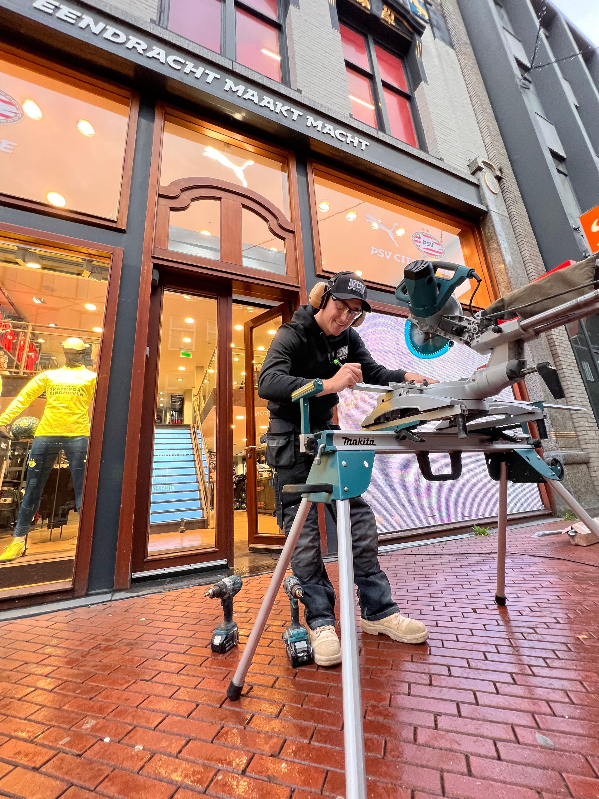 Chris werkt buiten aan de trap voor de PSV store