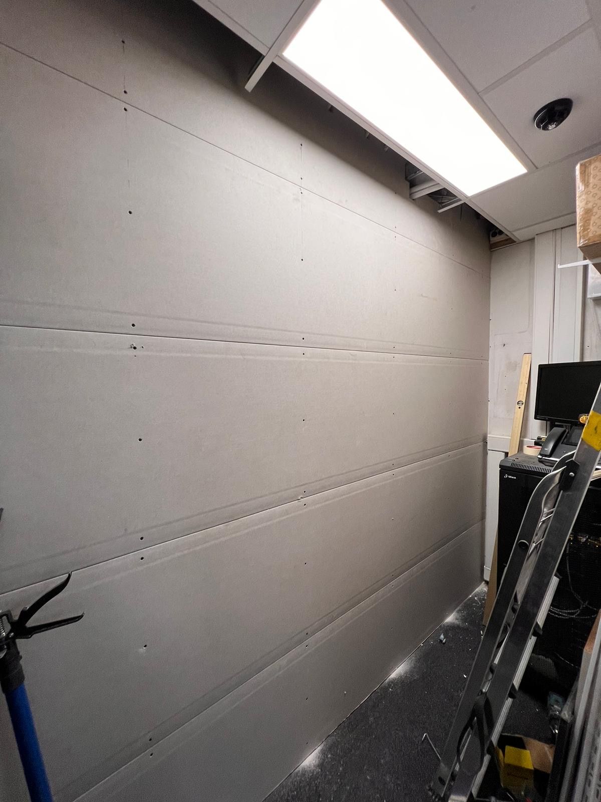 een kamer met een ladder en een computer op een bureau