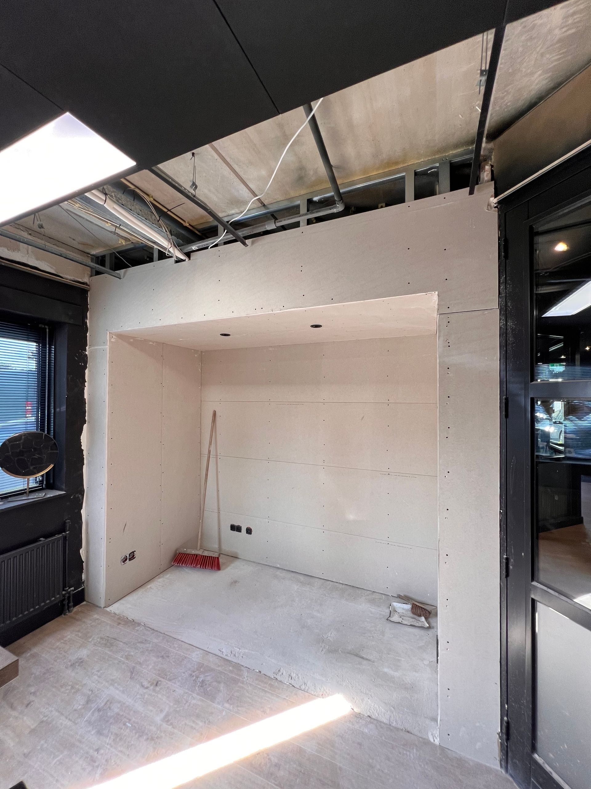 een kamer in aanbouw met een bezem op de vloer